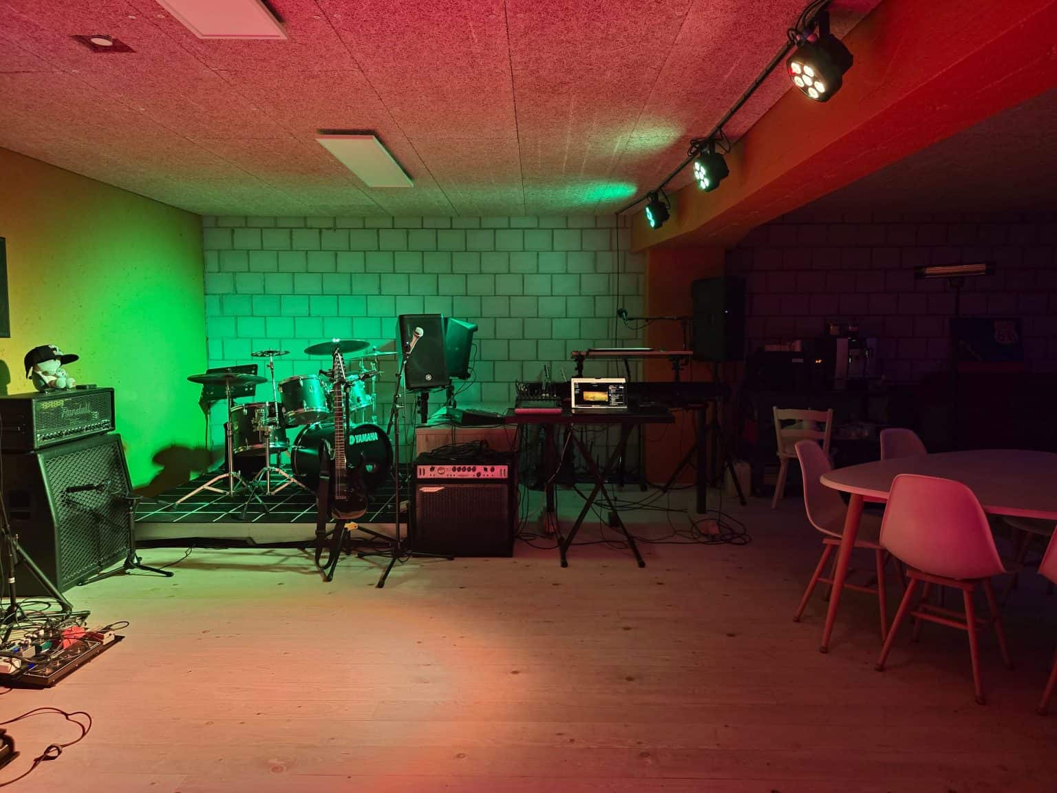 Der Proberaum mit Bühnenlicht: Drumset, Verstärker und Lounge-Ecke im Musikraum Grosshöchstetten